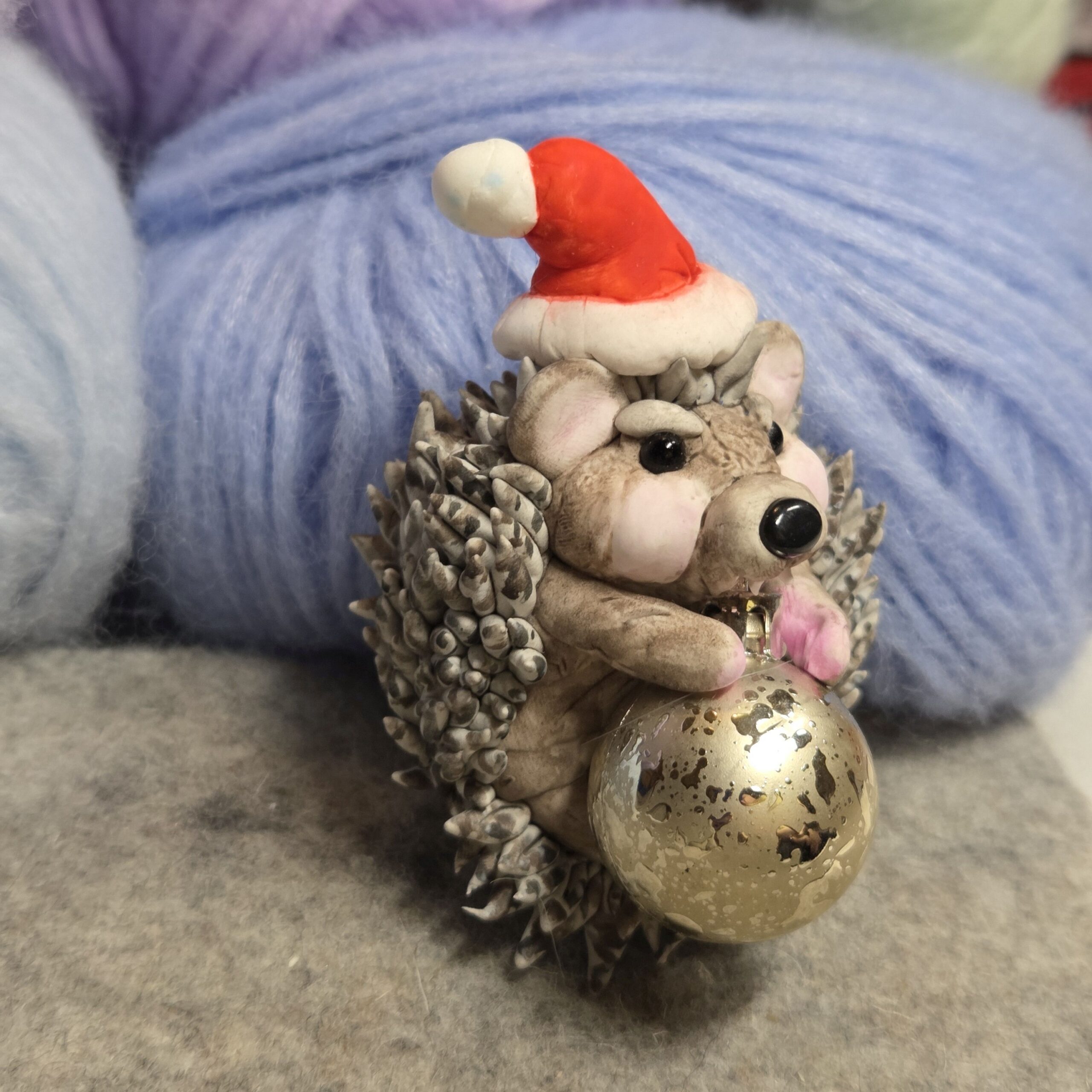 Igel beisst in Weihnachtskugel Dekofigur